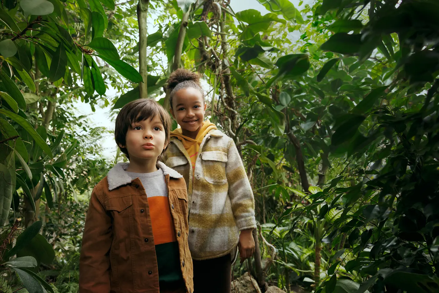 una niña y un niño con árboles